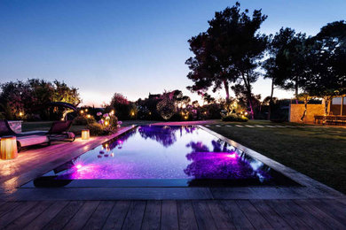 Cette image montre une grande piscine à débordement et avant design rectangle.