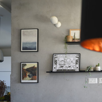 Graue Strukturwand mit Kunst und schmalen Regalen