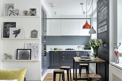 Small scandinavian kitchen in Moscow with raised-panel cabinets, grey cabinets, light hardwood floors and no island.