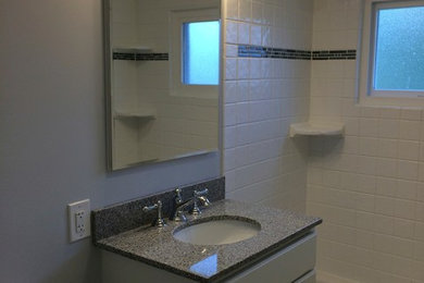 Bathroom - mid-sized traditional gray tile and porcelain tile slate floor bathroom idea in Newark with white cabinets, a one-piece toilet, gray walls, a drop-in sink and granite countertops
