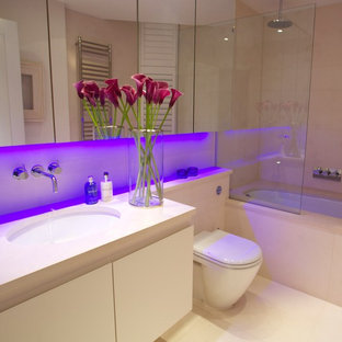 Idee per una stanza da bagno padronale minimal di medie dimensioni con ante lisce, ante bianche, vasca da incasso, vasca/doccia, WC monopezzo, piastrelle bianche, piastrelle in ceramica, pareti bianche, pavimento in cementine, lavabo integrato, top in onice, pavimento bianco e porta doccia a battente