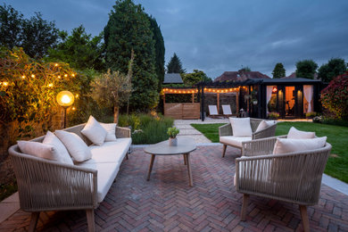 Medium sized traditional back partial sun garden seating for summer in Glasgow with brick paving and a stone fence.