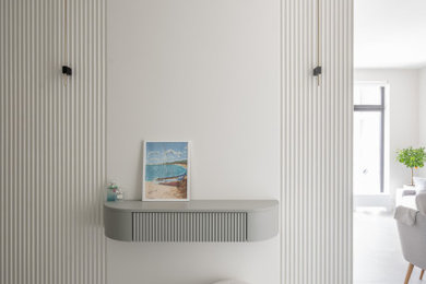 Foto de entrada contemporánea pequeña con paredes blancas, suelo de baldosas de porcelana, suelo gris, bandeja y panelado