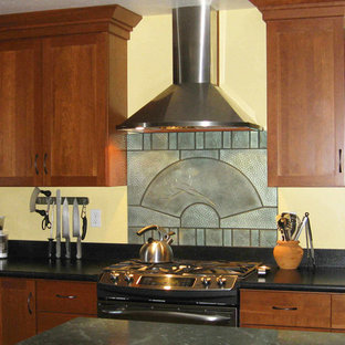 Idées déco pour une grande arrière-cuisine classique en L avec un placard à porte shaker, des portes de placard en bois brun, une crédence métallisée, une crédence en dalle métallique, un électroménager en acier inoxydable et un îlot central.