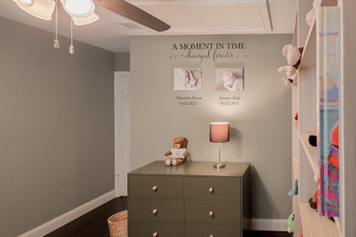 Small minimalist gender-neutral dark wood floor and brown floor nursery photo in Dallas with green walls