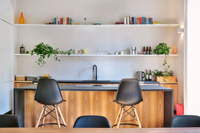 Open concept kitchen - mid-sized scandinavian single-wall open concept kitchen idea in Turin with flat-panel cabinets, medium tone wood cabinets, white backsplash and an island