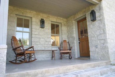 Mid-sized farmhouse stone back porch idea in Austin with a roof extension