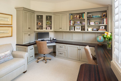 Ejemplo de despacho clásico de tamaño medio con biblioteca, paredes blancas, moqueta, escritorio empotrado y suelo beige