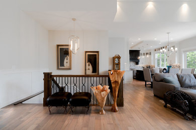 Example of a large trendy medium tone wood floor and brown floor entryway design in Calgary with white walls and a glass front door