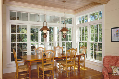 Example of a mid-sized farmhouse medium tone wood floor great room design in Other with yellow walls and no fireplace