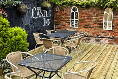 Photo of a medium sized traditional courtyard ground level wood railing terrace in Dorset with a bar area and no cover.
