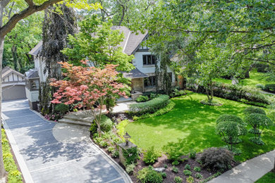Photo of a large traditional partial sun front yard concrete paver landscaping in Toronto for summer.
