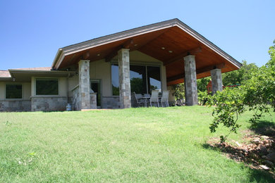Large craftsman beige one-story stone house exterior idea in Dallas with a hip roof