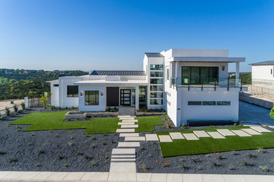 Large modern white two-story stucco exterior home idea in Austin