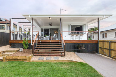 This is an example of a small transitional one-storey white house exterior in Brisbane with wood siding, a hip roof and a metal roof.