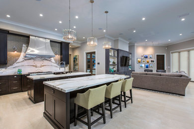 Inspiration for a large contemporary galley light wood floor open concept kitchen remodel in Jacksonville with shaker cabinets, dark wood cabinets, gray backsplash, stainless steel appliances and two islands