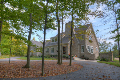 Example of a mid-sized classic beige two-story stone gable roof design in Columbus