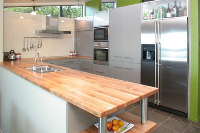 Inspiration for a modern kitchen in Wellington with wood benchtops.