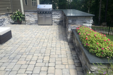 Example of a mid-sized trendy backyard stone patio container garden design in Raleigh