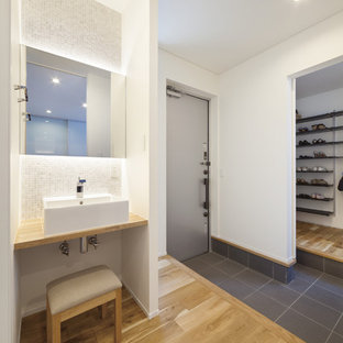 横浜の片開きドアインダストリアルスタイルのおしゃれな玄関 (白い壁、金属製ドア、黒い床) の写真