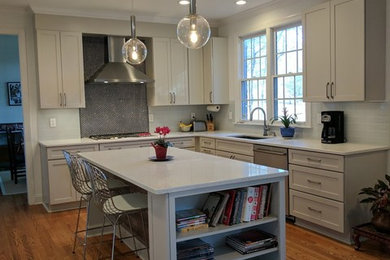 Inspiration for a contemporary u-shaped medium tone wood floor open concept kitchen remodel in Charlotte with an undermount sink, shaker cabinets, quartz countertops, white backsplash, glass tile backsplash, stainless steel appliances and an island