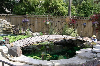 Photo of a large traditional backyard brick pond in Orange County.