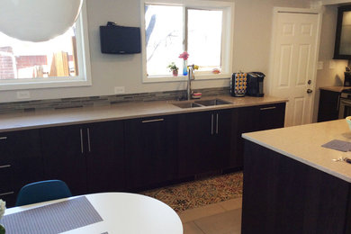Example of a mid-sized 1950s u-shaped eat-in kitchen design in Denver with flat-panel cabinets, brown cabinets, stainless steel appliances and an island