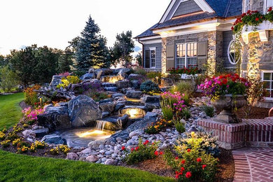 Photo of a traditional side yard partial sun garden in Denver with a water feature and brick pavers.