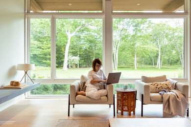 Esempio di un grande soggiorno design aperto con pareti bianche, parquet chiaro e pavimento beige