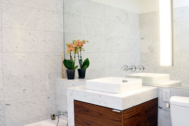Inspiration for a mid-sized contemporary 3/4 white tile and marble tile marble floor and white floor alcove bathtub remodel in Orange County with flat-panel cabinets, medium tone wood cabinets, a two-piece toilet, white walls, a vessel sink and marble countertops