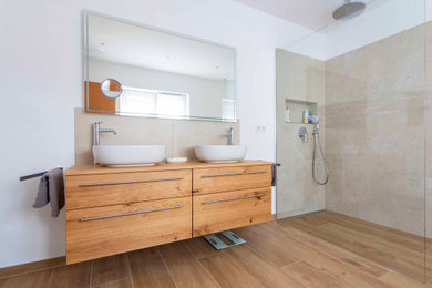 フランクフルトにあるお手頃価格の中くらいなコンテンポラリースタイルのおしゃれな浴室 (中間色木目調キャビネット、木製洗面台、ブラウンの洗面カウンター、洗面台2つ) の写真