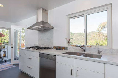 Enclosed kitchen - contemporary porcelain tile enclosed kitchen idea in Los Angeles with a double-bowl sink, flat-panel cabinets, white cabinets, marble countertops, gray backsplash, stone slab backsplash and stainless steel appliances