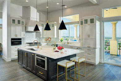 Example of a large transitional u-shaped medium tone wood floor and brown floor eat-in kitchen design in Sacramento with an undermount sink, shaker cabinets, white cabinets, quartz countertops, white backsplash, mosaic tile backsplash, stainless steel appliances, an island and white countertops