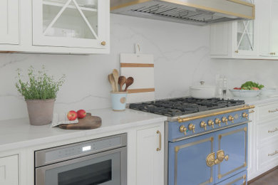 Mid-sized transitional kitchen photo in DC Metro with an undermount sink, recessed-panel cabinets, white cabinets, quartzite countertops, white backsplash, stone slab backsplash, colored appliances, an island and white countertops