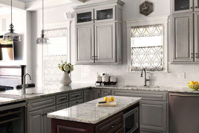 Design ideas for a mid-sized transitional l-shaped kitchen pantry in Boston with an undermount sink, raised-panel cabinets, grey cabinets, granite benchtops, white splashback, subway tile splashback, stainless steel appliances, with island, dark hardwood floors and brown floor.
