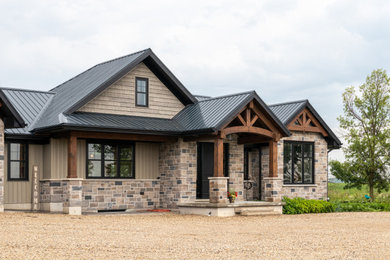 Inspiration pour une façade de maison beige chalet en planches et couvre-joints de taille moyenne et de plain-pied avec un revêtement mixte, un toit à deux pans, un toit en métal et un toit noir.