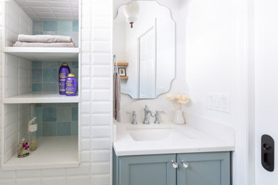 Small elegant master white tile and porcelain tile mosaic tile floor, white floor and single-sink bathroom photo in New York with shaker cabinets, blue cabinets, a two-piece toilet, white walls, an undermount sink, quartz countertops, white countertops, a niche and a built-in vanity