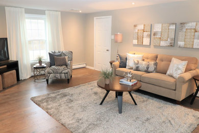 Example of a large open concept medium tone wood floor family room design in Philadelphia with gray walls, no fireplace and a tv stand