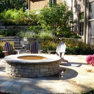 Raised fire pit made of lannon stone topped in bluestone