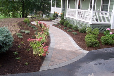 This is an example of a front yard garden in Other with brick pavers.