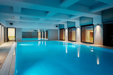 Ispirazione per un'ampia piscina coperta design con piastrelle