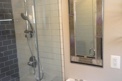 Photo of a small contemporary 3/4 bathroom in Philadelphia with a pedestal sink, glass-front cabinets, an alcove shower, a two-piece toilet, black tile, ceramic tile, grey walls and ceramic floors.