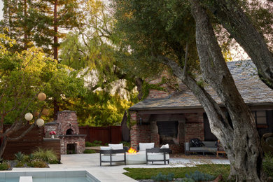 Inspiration for a french country partial sun backyard river rock and wood fence landscaping in San Francisco with a fire pit for summer.