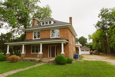 Large arts and crafts red two-story brick exterior home photo in Other with a clipped gable roof