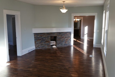 Large country formal and open concept living room photo in Grand Rapids with blue walls, a corner fireplace, a stone fireplace and no tv