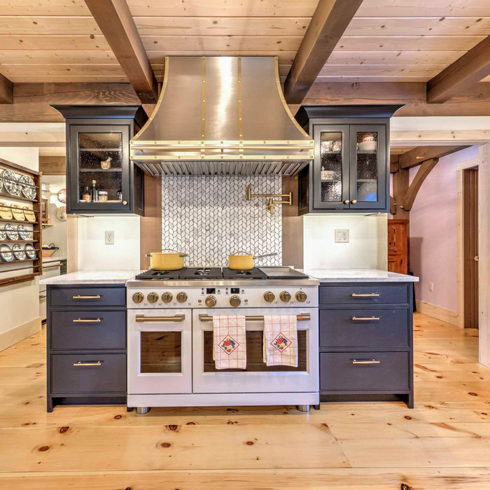 Eat-in kitchen - large l-shaped light wood floor and exposed beam eat-in kitchen idea in Other with a farmhouse sink and white appliances