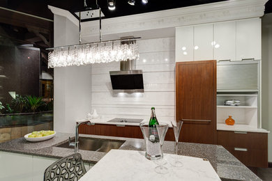 Trendy l-shaped eat-in kitchen photo in Chicago with quartz countertops, stone slab backsplash, a farmhouse sink, flat-panel cabinets, white cabinets, stainless steel appliances and an island