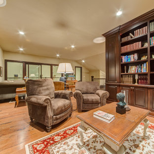 Diseño de despacho clásico, extra grande, con suelo de madera clara, chimenea tradicional, marco de chimenea de baldosas y/o azulejos, escritorio independiente y suelo marrón