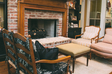 Example of a mid-sized classic open concept medium tone wood floor family room design in New Orleans with yellow walls, a standard fireplace, a brick fireplace and no tv