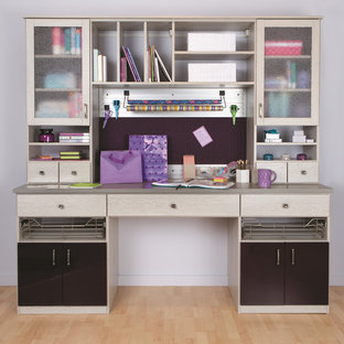 This is an example of a medium sized modern craft room in Detroit with purple walls, light hardwood flooring, no fireplace, a built-in desk and beige floors.